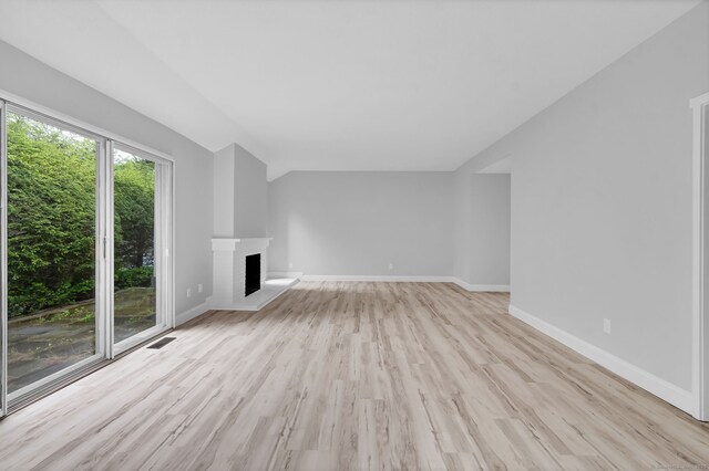 170 Heritage Vlg Unit B, Southbury, CT 06488 - unfurnished living room with light wood finished floors, a brick fireplace, and vaulted ceiling
