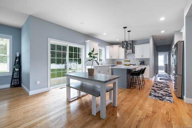 11 Mariani Dr, Southington, CT 06489 - kitchen with freestanding refrigerator, a center island, wall chimney exhaust hood, light countertops, and white cabinets