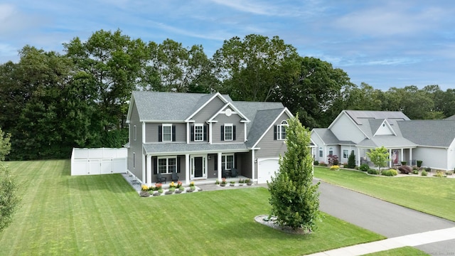 11 Mariani Dr, Southington, CT 06489 - traditional-style house with a porch, an attached garage, a front yard, asphalt driveway, and view of wooded area