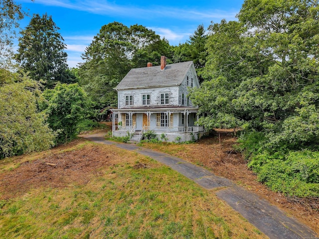 4 Bindloss Rd, Groton, CT 06355 - view of front of home with covered porch, a chimney, a front yard, and a wooded view