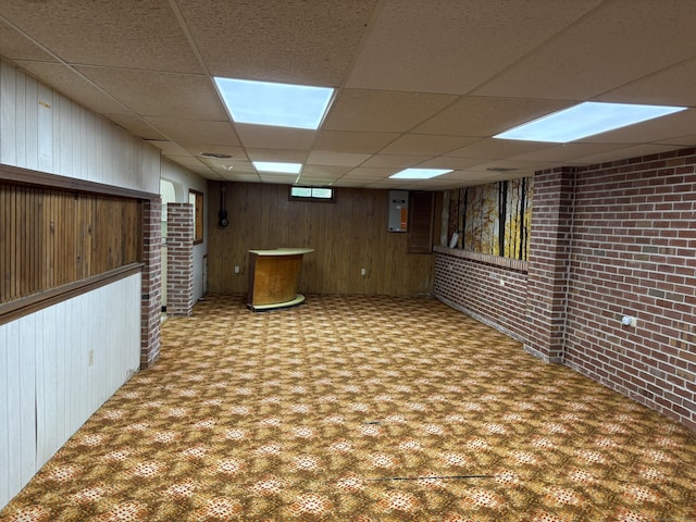 15 S Meadow Dr, Danbury, CT 06811 - finished basement with a paneled ceiling, brick wall, carpet flooring, and wood walls