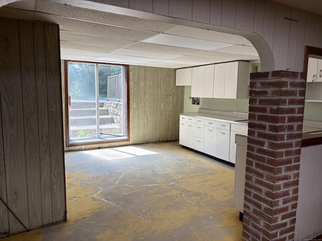 15 S Meadow Dr, Danbury, CT 06811 - kitchen featuring white cabinets, light countertops, concrete flooring, wood walls, and arched walkways