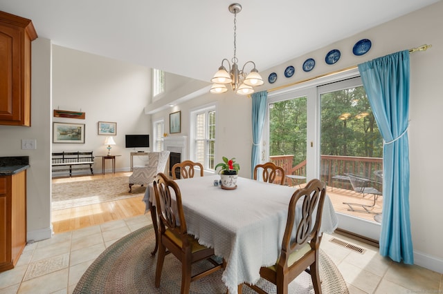 2 Spinnaker Dr Unit 2, East Lyme, CT 06357 - dining space with light tile patterned floors, a chandelier, and a fireplace