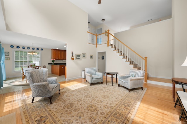 2 Spinnaker Dr Unit 2, East Lyme, CT 06357 - living area with light wood-style floors, a chandelier, stairway, and a high ceiling