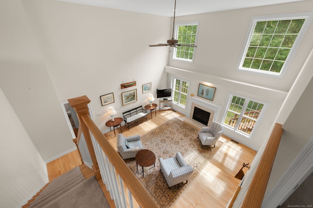 2 Spinnaker Dr Unit 2, East Lyme, CT 06357 - living area with wood finished floors, a towering ceiling, a fireplace, and a ceiling fan