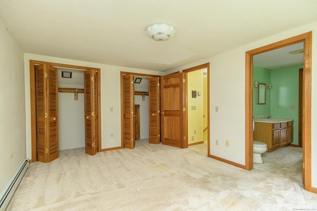 132 Wade Rd, Pomfret, CT 06259 - unfurnished bedroom featuring baseboard heating, two closets, connected bathroom, light carpet, and a textured ceiling