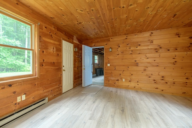 132 Wade Rd, Pomfret, CT 06259 - empty room with a baseboard radiator, plenty of natural light, wooden walls, light wood finished floors, and wooden ceiling