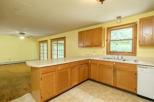 132 Wade Rd, Pomfret, CT 06259 - kitchen with white dishwasher, a peninsula, a baseboard heating unit, light countertops, and a textured ceiling