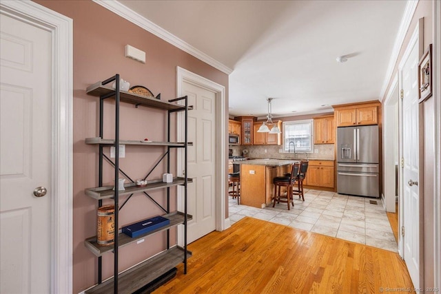 70 Albemarle St, Bridgeport, CT 06606 - kitchen with appliances with stainless steel finishes, a kitchen bar, tasteful backsplash, ornamental molding, and a center island