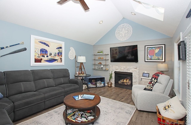362 Main St, Meriden, CT 06451 - living area featuring wood finished floors, ceiling fan, vaulted ceiling, a warm lit fireplace, and a skylight