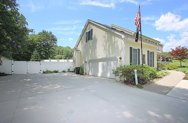 362 Main St, Meriden, CT 06451 - view of side of home with a gate, an attached garage, and driveway