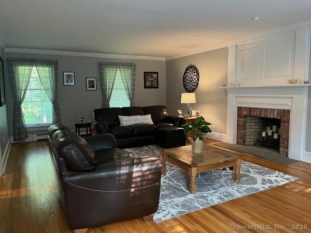 47 Merwin Brook Rd, Brookfield, CT 06804 - living area with wood finished floors, a fireplace, and ornamental molding