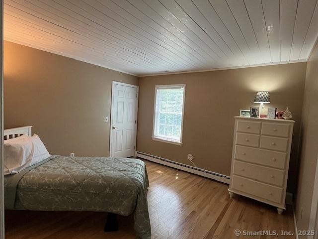 47 Merwin Brook Rd, Brookfield, CT 06804 - bedroom with baseboard heating, wood finished floors, wooden ceiling, and crown molding