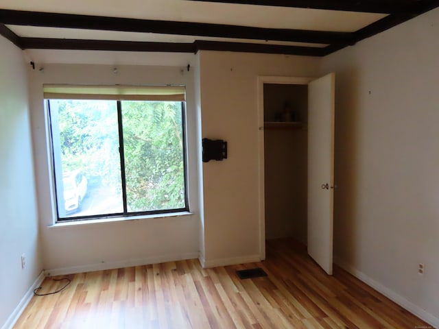 1 Birch Ln Unit D, East Haven, CT 06513 - unfurnished bedroom with light wood-style floors, beamed ceiling, and a closet