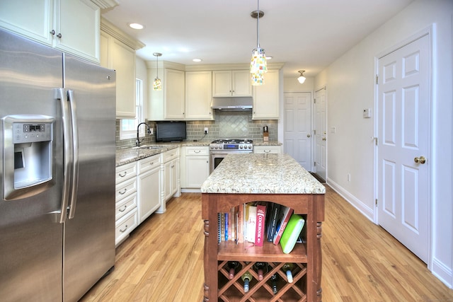 1221 Merritt St, Fairfield, CT 06825 - kitchen with stainless steel appliances, light wood-type flooring, under cabinet range hood, decorative backsplash, and pendant lighting
