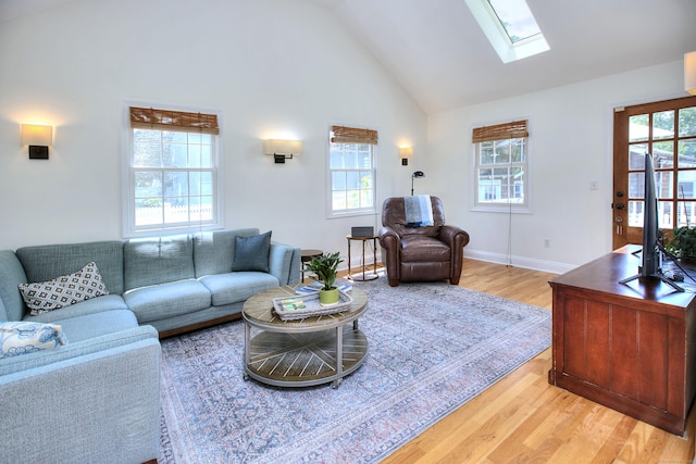 1221 Merritt St, Fairfield, CT 06825 - living room featuring light wood-style floors, healthy amount of natural light, a skylight, and high vaulted ceiling