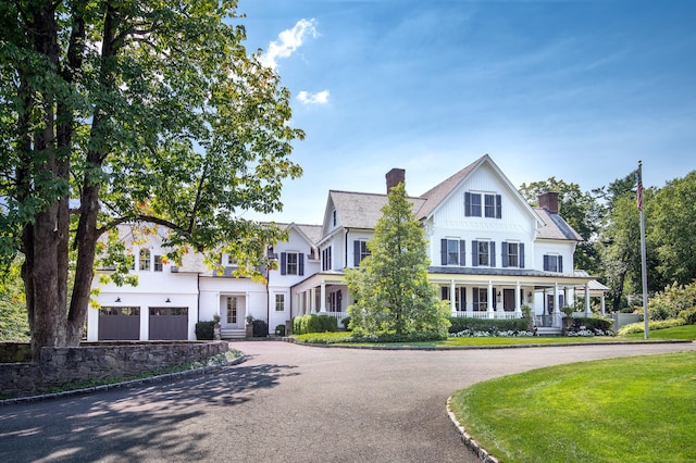 14 Market St, Ridgefield, CT 06877 - view of front of property featuring curved driveway, a chimney, a garage, and a porch
