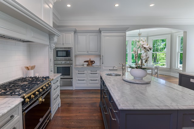 14 Market St, Ridgefield, CT 06877 - kitchen featuring appliances with stainless steel finishes, dark wood-type flooring, a center island with sink, light stone countertops, and crown molding