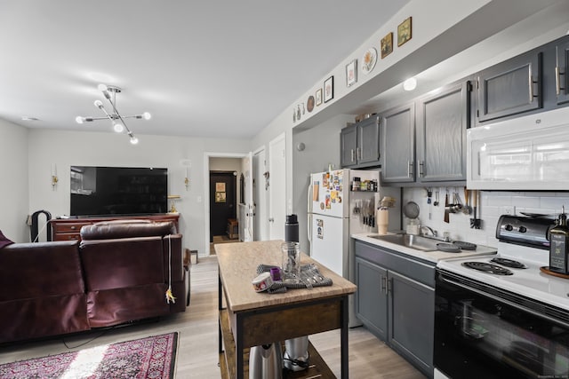 212 Sheffield Ave, New Haven, CT 06511 - kitchen with white appliances, backsplash, light wood finished floors, and a chandelier