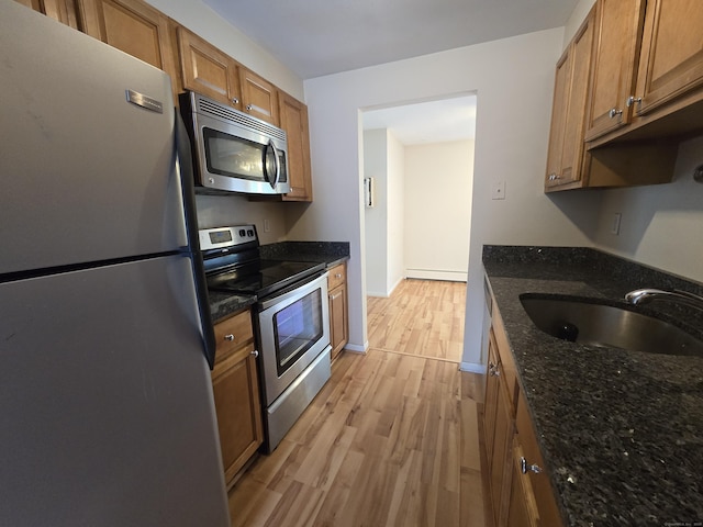 655 Talcottville Rd Apt 89, Vernon, CT 06066 - kitchen featuring stainless steel appliances, light wood finished floors, brown cabinetry, and dark stone counters
