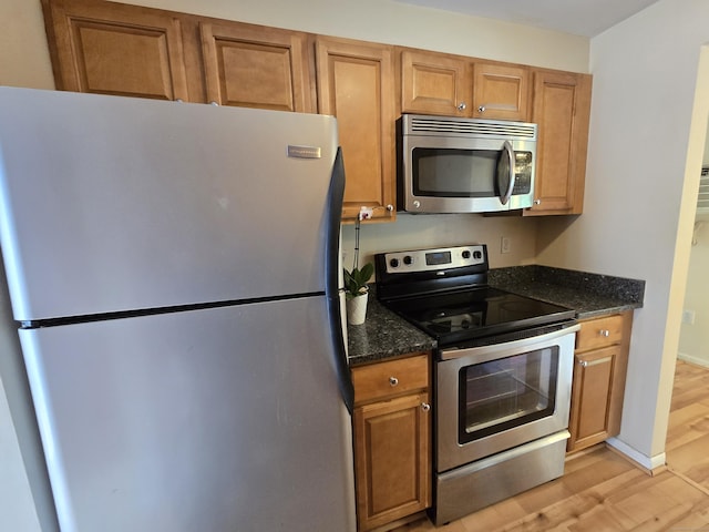 655 Talcottville Rd Apt 89, Vernon, CT 06066 - kitchen featuring appliances with stainless steel finishes, light wood-style flooring, brown cabinets, and dark stone countertops