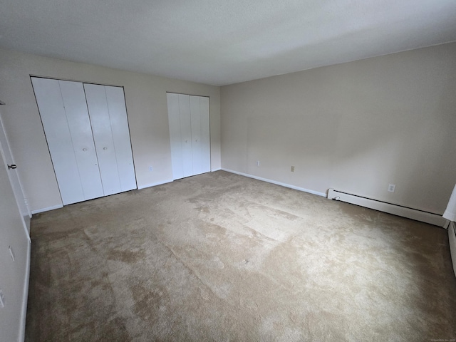 655 Talcottville Rd Apt 89, Vernon, CT 06066 - unfurnished bedroom with multiple closets, a baseboard heating unit, and carpet floors