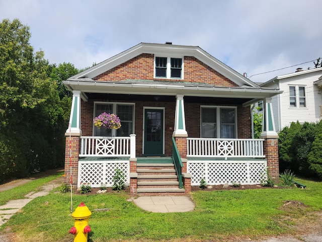 50 Tracy Ave, Waterbury, CT 06706 - view of front of home with brick siding, a porch, and a front yard