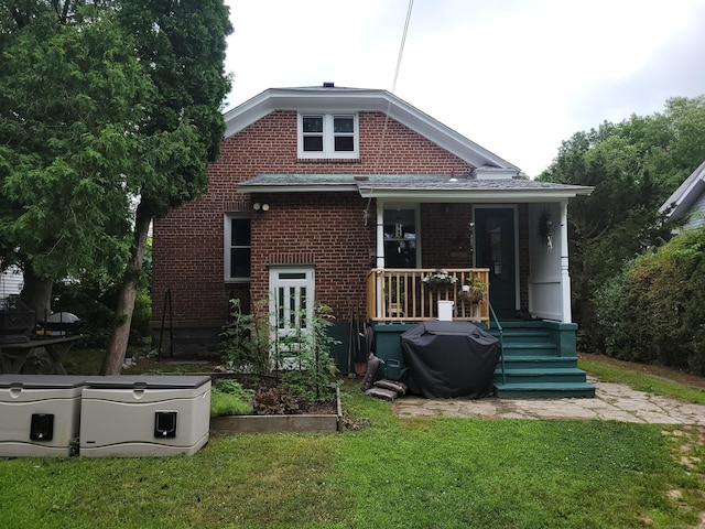 50 Tracy Ave, Waterbury, CT 06706 - rear view of house featuring a lawn, brick siding, a vegetable garden, and a wooden deck