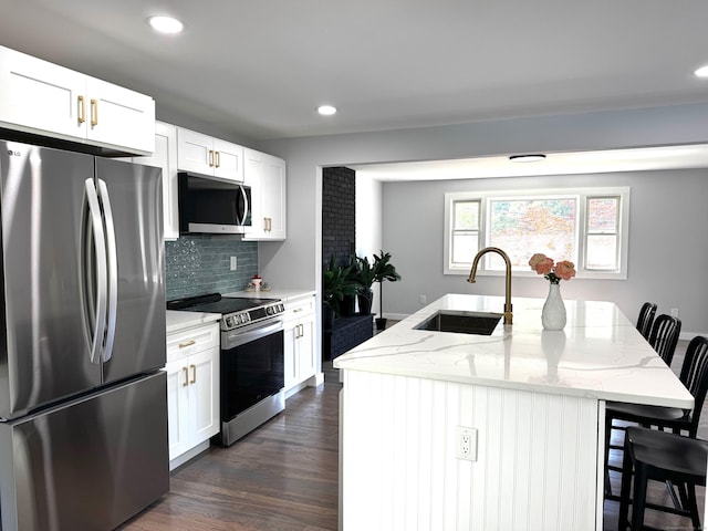 26 Nejako Dr, Middletown, CT 06457 - kitchen with appliances with stainless steel finishes, light stone countertops, a kitchen bar, tasteful backsplash, and dark wood-style flooring