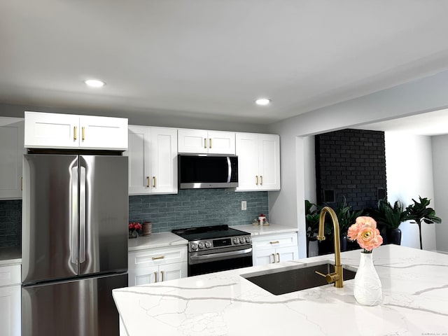 26 Nejako Dr, Middletown, CT 06457 - kitchen with stainless steel appliances, decorative backsplash, light stone counters, white cabinetry, and recessed lighting