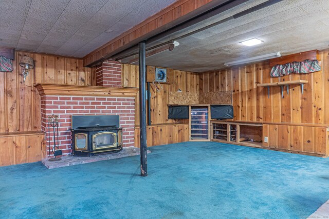 156 Overhill Dr, Berlin, CT 06037 - unfurnished living room featuring wooden walls, carpet flooring, and a wood stove