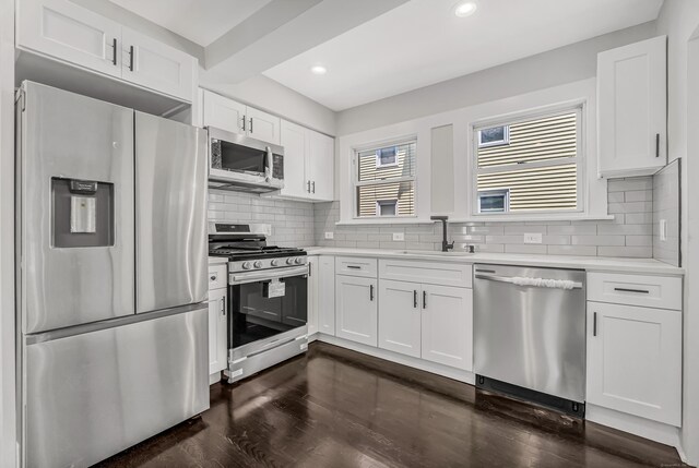 222 Wakelee Ave, Ansonia, CT 06401 - kitchen with appliances with stainless steel finishes, light countertops, white cabinets, dark wood-type flooring, and backsplash