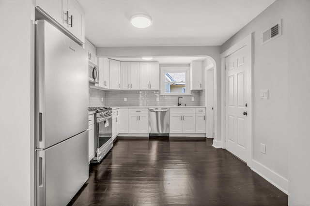 222 Wakelee Ave, Ansonia, CT 06401 - kitchen with appliances with stainless steel finishes, backsplash, dark wood-style flooring, light countertops, and white cabinetry