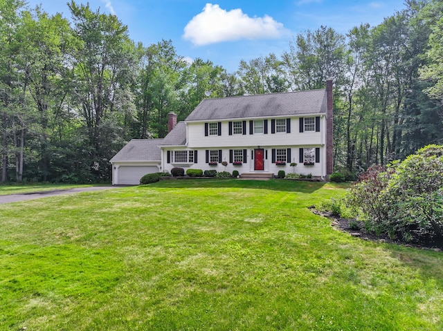 4 Adams Rd, Simsbury, CT 06089 - colonial house featuring a chimney, driveway, an attached garage, and a front yard