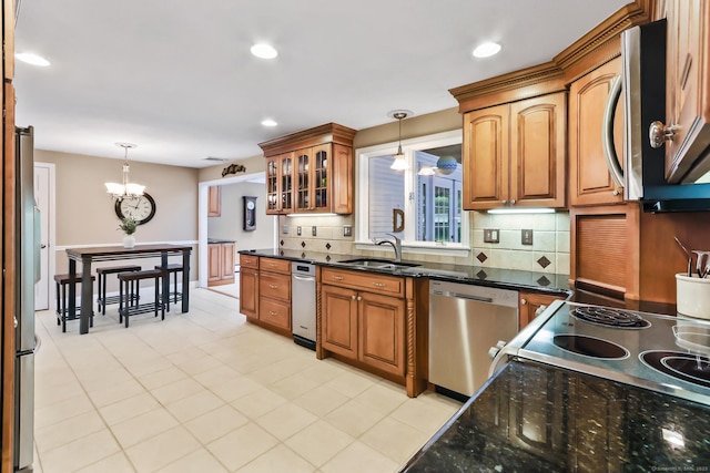 4 Adams Rd, Simsbury, CT 06089 - kitchen with appliances with stainless steel finishes, pendant lighting, backsplash, brown cabinetry, and a chandelier
