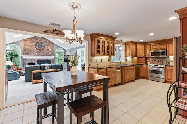 4 Adams Rd, Simsbury, CT 06089 - kitchen with stainless steel appliances, a chandelier, dark countertops, lofted ceiling, and brown cabinetry