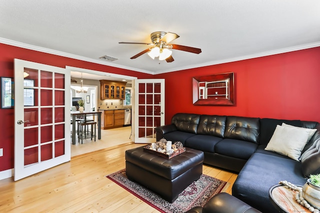 4 Adams Rd, Simsbury, CT 06089 - living room featuring a ceiling fan, a chandelier, light wood-style flooring, ornamental molding, and french doors