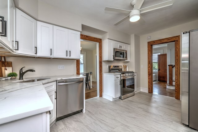 21 Orange Ter, West Haven, CT 06516 - kitchen featuring appliances with stainless steel finishes, white cabinets, a ceiling fan, and light stone countertops