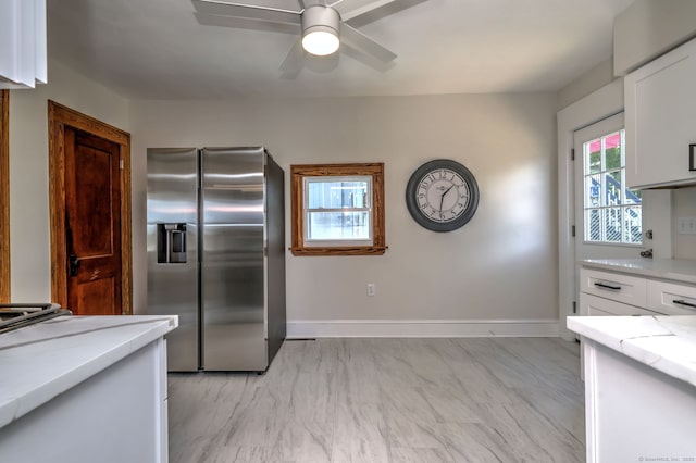 21 Orange Ter, West Haven, CT 06516 - kitchen with stainless steel refrigerator with ice dispenser, white cabinets, ceiling fan, light marble finish flooring, and light stone countertops