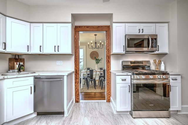 21 Orange Ter, West Haven, CT 06516 - kitchen with appliances with stainless steel finishes, a chandelier, and white cabinets