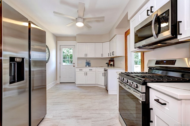 21 Orange Ter, West Haven, CT 06516 - kitchen featuring stainless steel appliances, light marble finish flooring, a ceiling fan, white cabinetry, and light stone counters