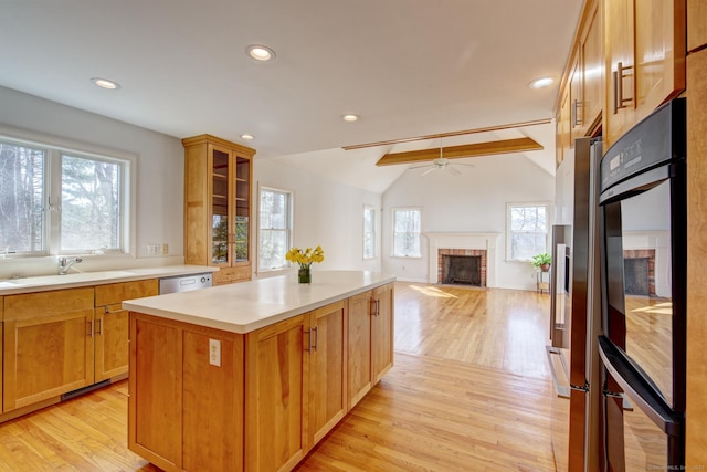37 Skyline Dr, Groton, CT 06340 - kitchen featuring a fireplace, a center island, a ceiling fan, light wood-style floors, and light countertops