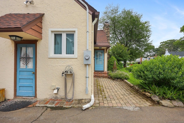 20 Cedar Crest Pl, Norwalk, CT 06854 - doorway to property featuring stucco siding and a chimney
