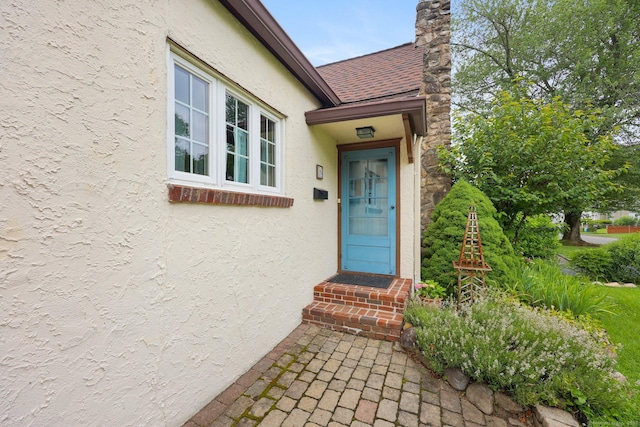 20 Cedar Crest Pl, Norwalk, CT 06854 - property entrance with stucco siding, roof with shingles, and a chimney