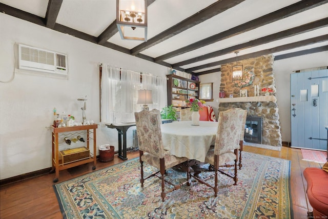 20 Cedar Crest Pl, Norwalk, CT 06854 - dining area featuring a wall unit AC, beam ceiling, wood finished floors, and a stone fireplace