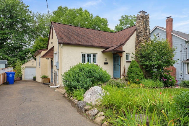 20 Cedar Crest Pl, Norwalk, CT 06854 - tudor-style house with stucco siding, roof with shingles, an outbuilding, a detached garage, and a chimney