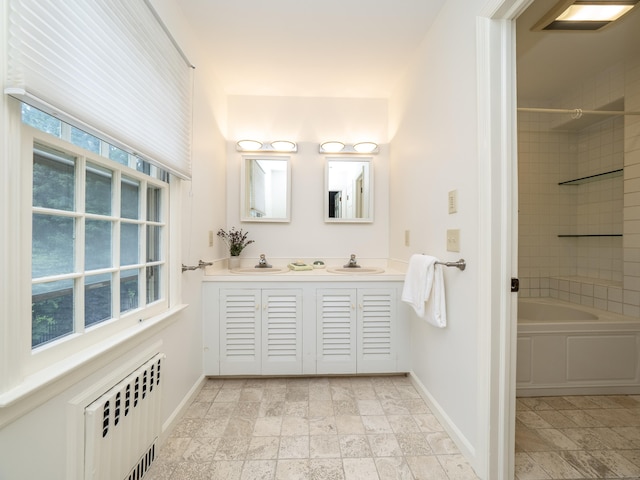 51 Powderhorn Dr, Ridgefield, CT 06877 - bathroom featuring double vanity, stone tile flooring, radiator heating unit, and shower / washtub combination