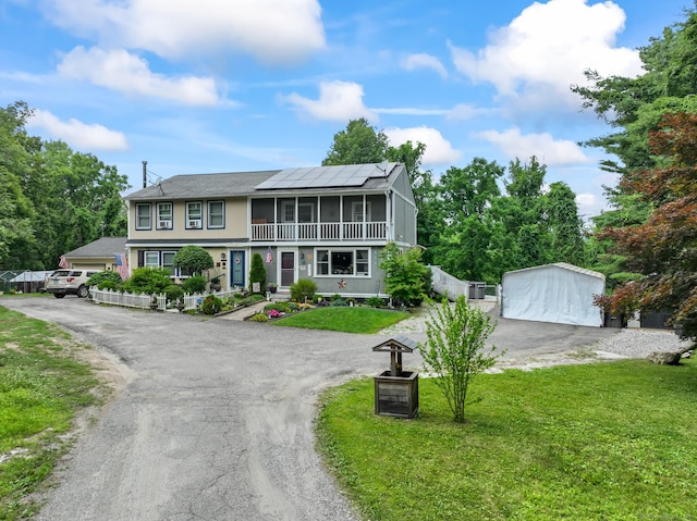 7 Pheasant Run Rd Unit 1, Kent, CT 06757 - view of front facade featuring a front lawn, a detached garage, a sunroom, roof mounted solar panels, and driveway
