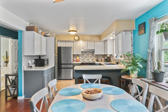 7 Pheasant Run Rd Unit 1, Kent, CT 06757 - kitchen with freestanding refrigerator, black microwave, a peninsula, decorative backsplash, and light countertops