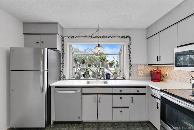 93 Cosey Beach Ave Apt 5, East Haven, CT 06512 - kitchen with stainless steel appliances, light countertops, white cabinets, a textured ceiling, and hanging light fixtures